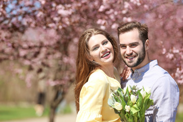 Naklejka premium Young lovely couple walking in spring park