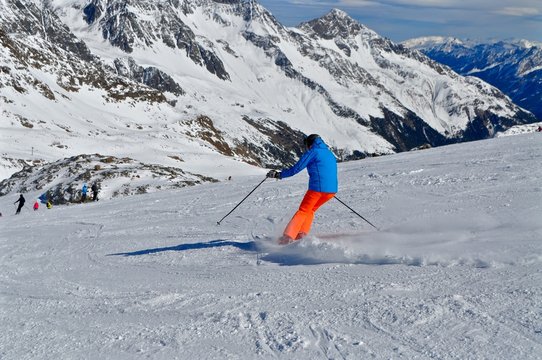 Skifahrer fährt in den Tiroler Alpen den Berg hinunter