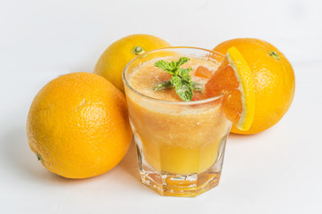 Fresh orange juice, mint and ice on dark background, top view