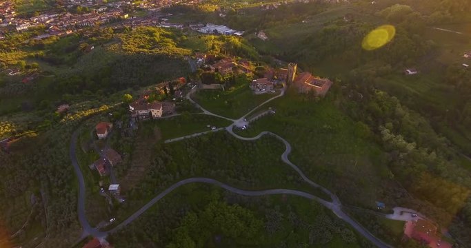 Aerial shot, a small tuscan hamlet on the hill in the sunset light in Italy, 4K