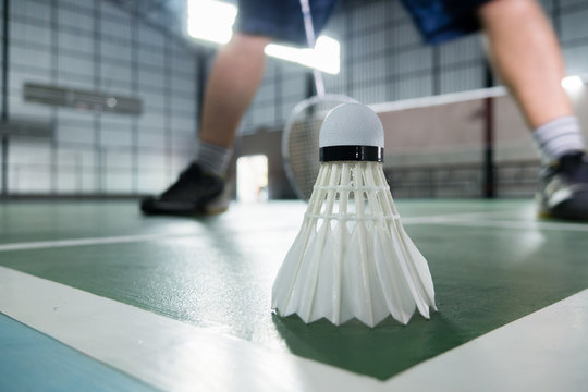 sports concept.Badmintons ball (shuttlecock) and racket ,badminton courts with players competing modern gym in background,selective focus,vintage color