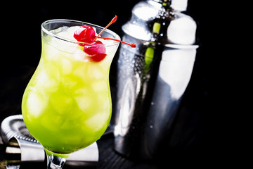 Alcoholic cocktail with whiskey, liqueur, orange juice, tangerine, cherry and crushed ice in a...