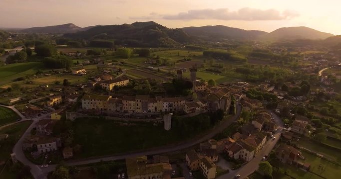 Aerial shot, a small tuscan hamlet Nozzano castello on the hill in the sunset light in Italy, 4K