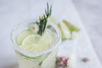 fresh homemade drink with flowers and lime on kitchen background