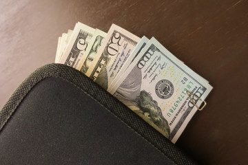 A lot of one hundred dollar bills in a bag plan for travel