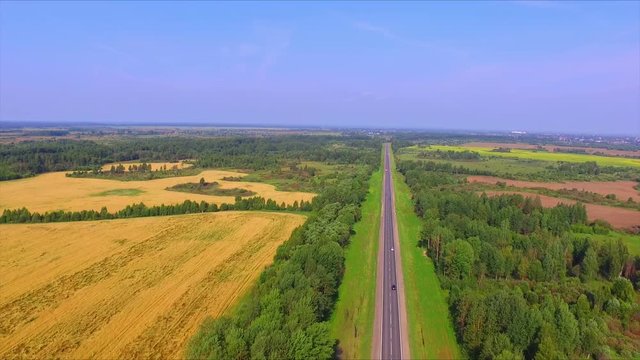 Drone flight over the highway among the ripe rye fields