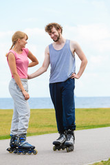 Fototapeta premium Couple wearing rollerskates looking at each other