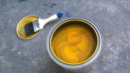 Yellow paint  cans and brush 