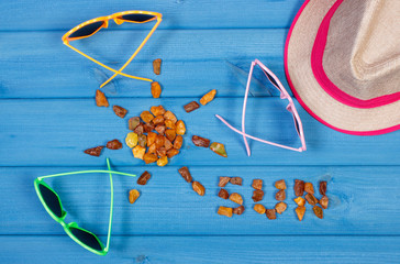 Shape of sun with word sun made of amber stones and accessories for vacation, summer time
