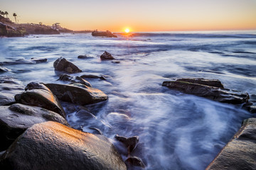 Sun setting over a rocky beach