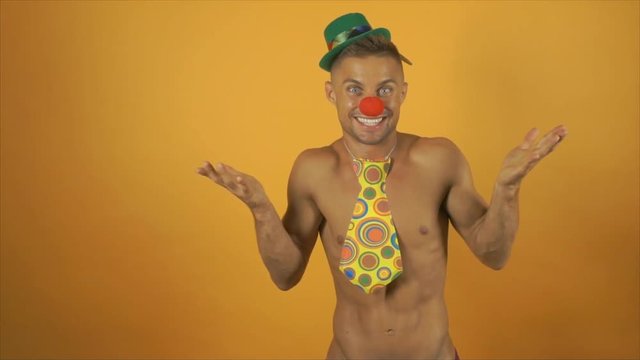 Sexy funny clown with no shirt on. Yellow background.  