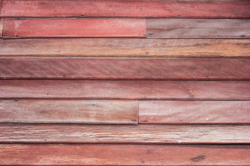 red wooden plank wall showing natural grain and texture, perfect for rustic design, construction, or background use.