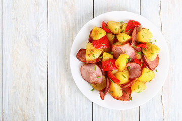 roasted potato wedges with sausages, top view