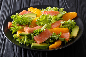 Beautiful food: salad of salted salmon, oranges, avocado and lettuce close-up. horizontal