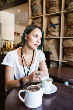 Jeune femme devant sa tasse de thé dans un bar