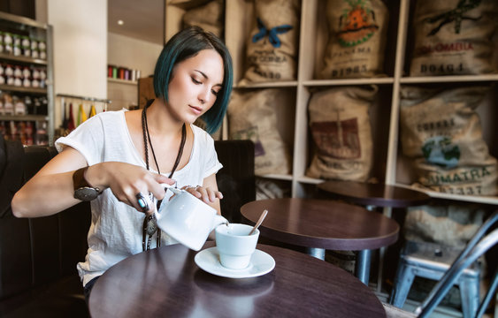 Jeune femme sert une tasse de thé dans un bar