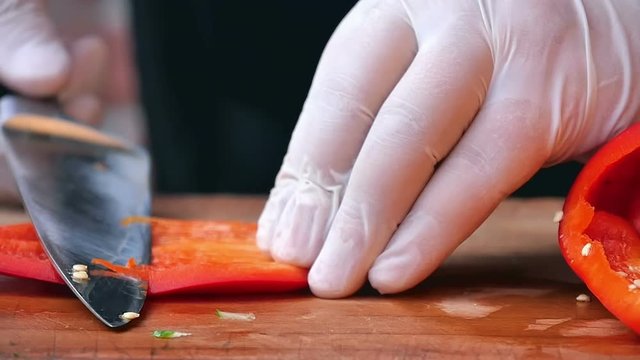 utting red pepper on wooden table