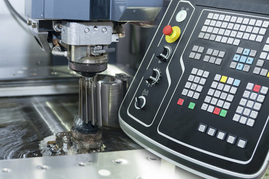 Abstract scene of close-up of the wire - EDM CNC machine while cutting the sample work pieces in light blue tone and controller panel