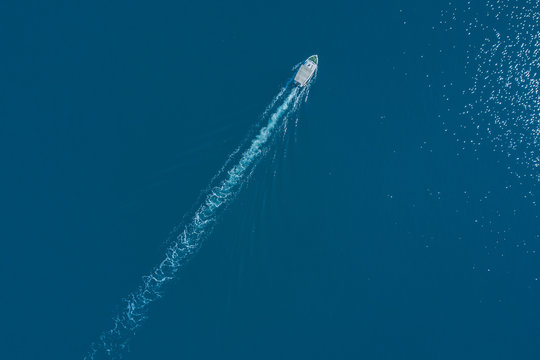 Top View Of A White Boat Sailing To The Blue Sea