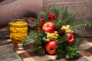 Fototapeta na wymiar Winter bouquet of fir twigs and Mimosa and ashberry and red apples