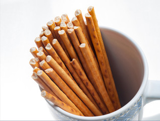 closeup top view of sticks in a cup over white background