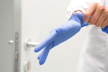 Mani che indossano guanti il gomma colore blu