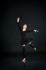 Beautiful Female Ballet Dancer dancing on Black Background