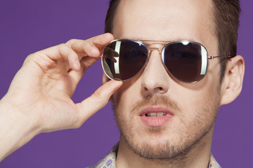 close-up portrait of guy with glasses on a purple background