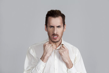 the guy on the grey background gets mad and squeezes her hands into fists