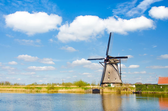 Painting beautiful picture of windmills in Kinderdijk, Netherlands, Europe against the backdrop of a cloudy sky.