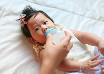 Asian baby infant eating milk from bottle