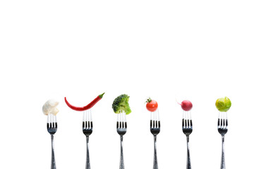 fresh vegetables on forks isolated on white, healthy living concept