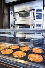 Pizza on sale on store shelves and oven