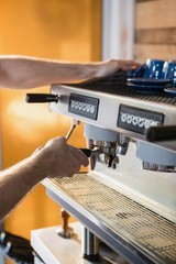 Waiter preparing coffee from coffee machine