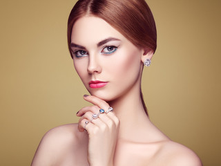 Fashion portrait of young beautiful woman with jewelry. Blonde girl. Perfect make-up and hairstyle.  Beauty style woman with diamond accessories. Silver earrings