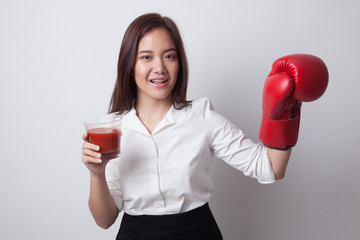 Young Asian woman with tomato juice and boxing glove.