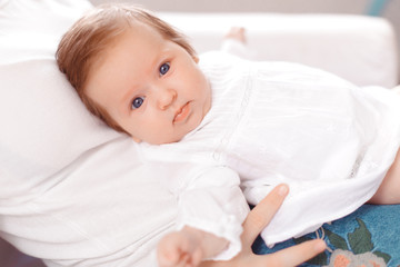 Young mother and newborn baby in white bedroom