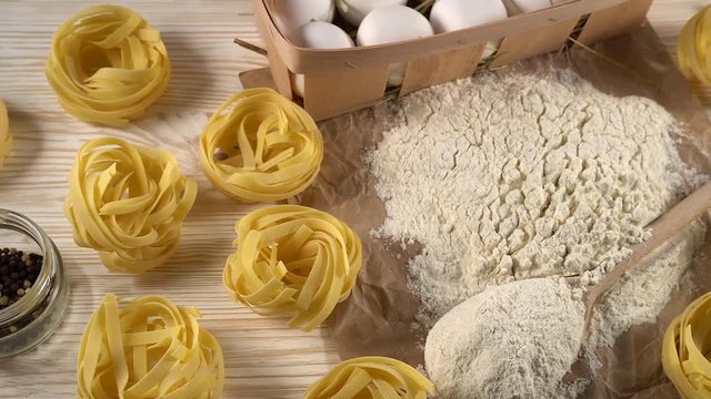 pasta, eggs, oil, garlic and flour on wooden background
