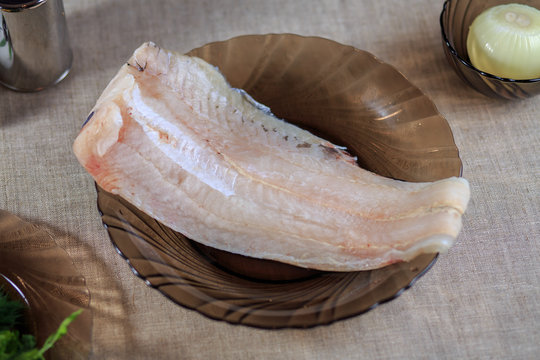 Fillet is fresher than fish on a plate on a gray background