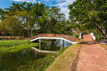 Fototapeta na wymiar Landscape of alley and bridge across canal in Ayutthaya park