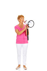 Senior smiling woman screaming through a megaphone