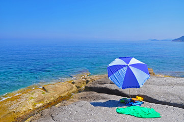 Beach umbrella on the stone shore