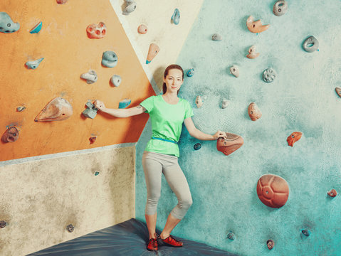 Sporty woman standing in climbing gym.