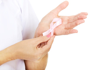 Elderly female doctor or nurse holds pink breast cancer awareness ribbon