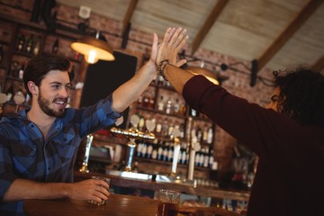 Two young men giving high five to each other