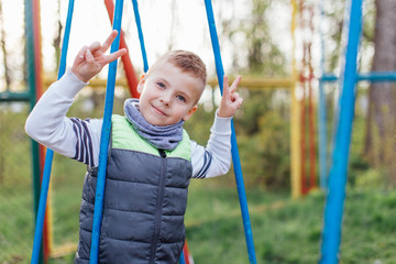Little boy play on playground with blur park background