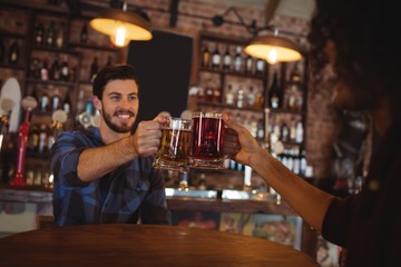 Two young men toasting their beer mugs
