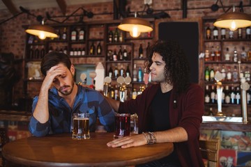 Man comforting his depressed friend