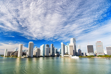 Obraz premium Aerial view of Miami skyscrapers with blue cloudy sky, boat sail