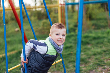 Little boy play on playground with blur park background
